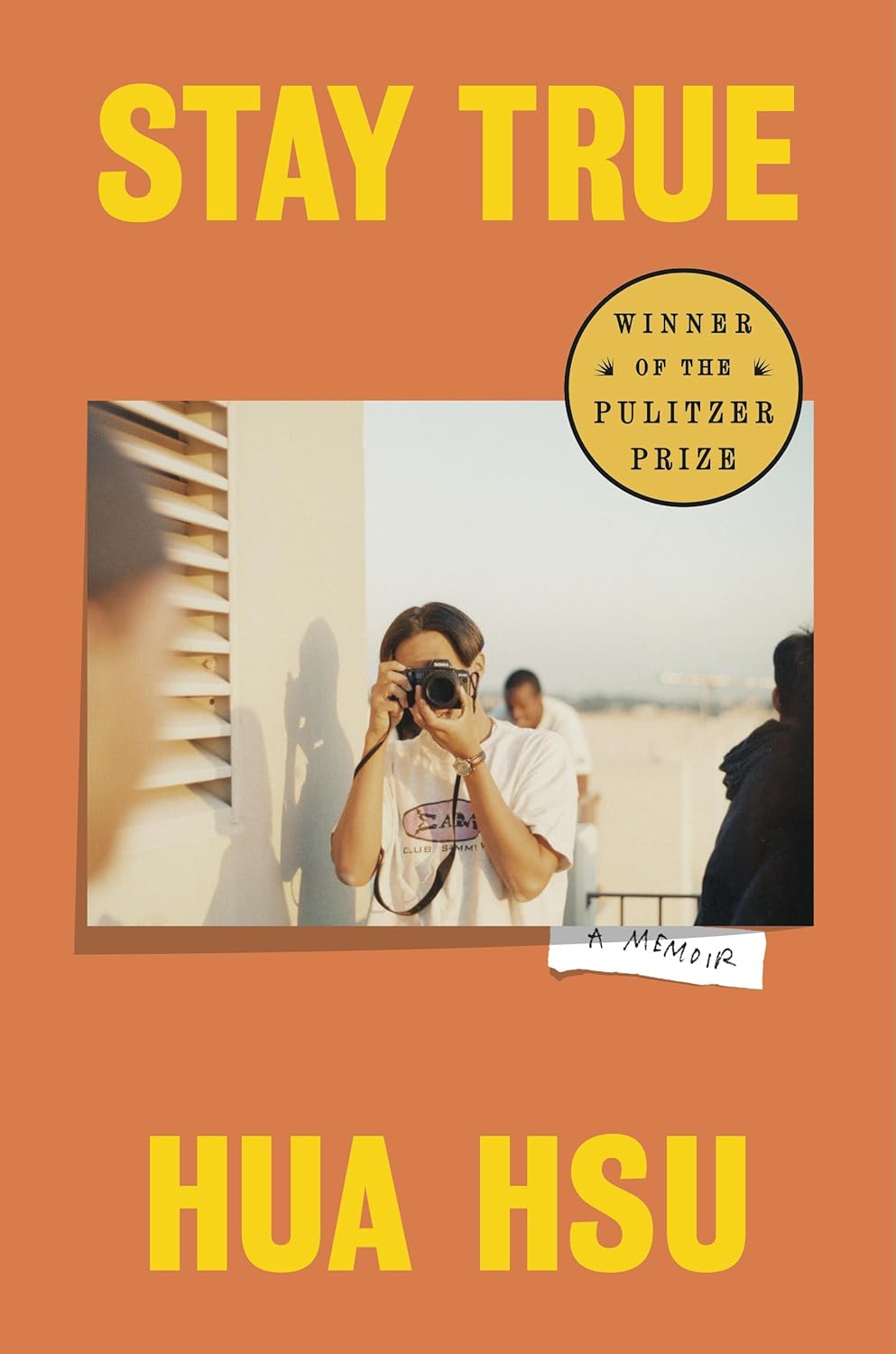 A picture of a book cover. The image on the cover is of a man holding a camera
